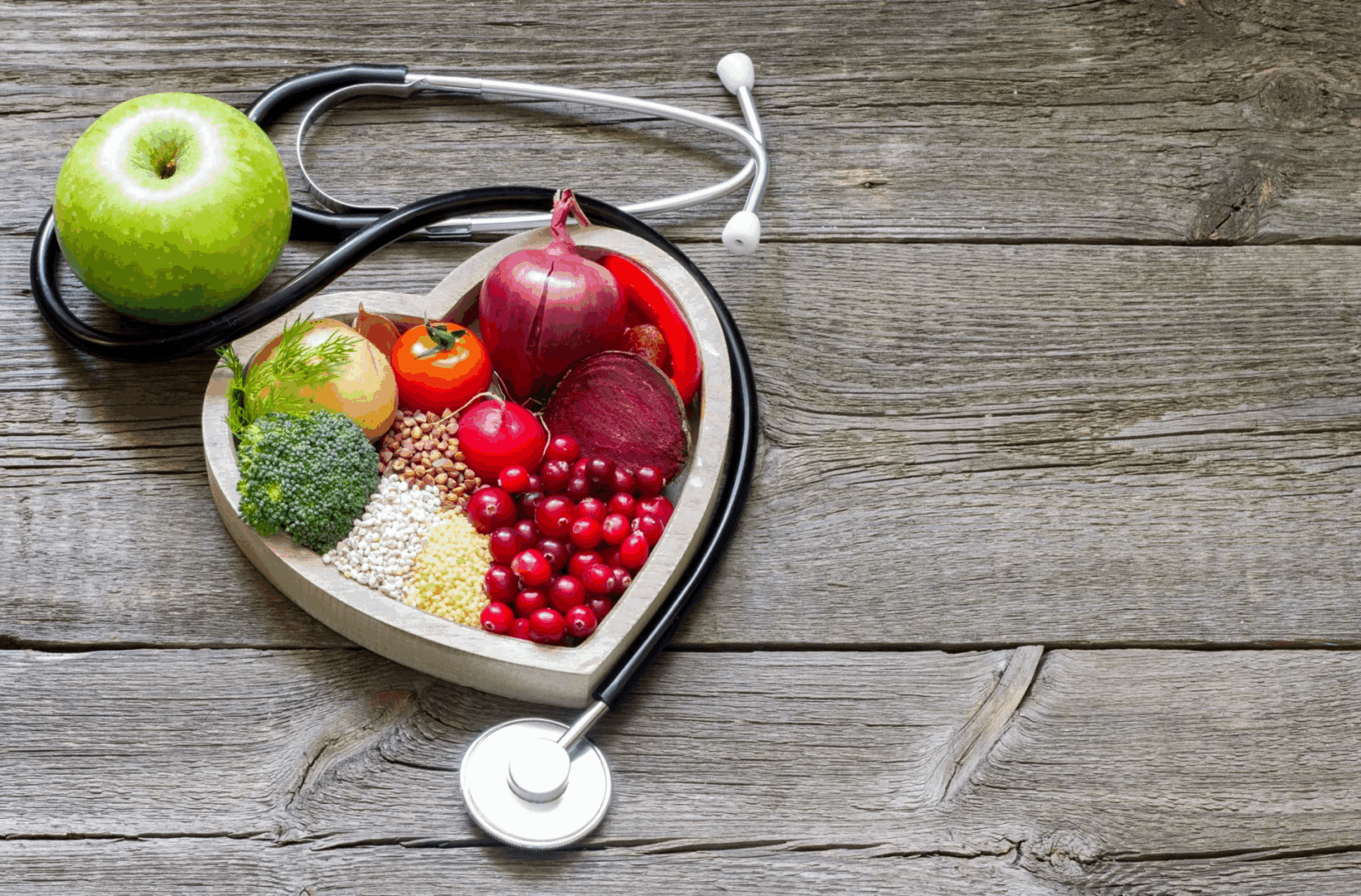 Healthy foods with stethoscope on wooden table